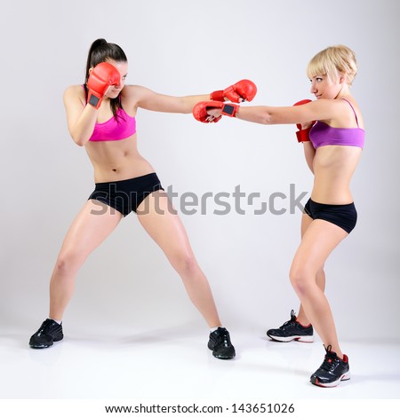 sport training of two boxing young woman, studio