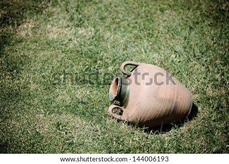 ancient jug are on grass-plot, toned