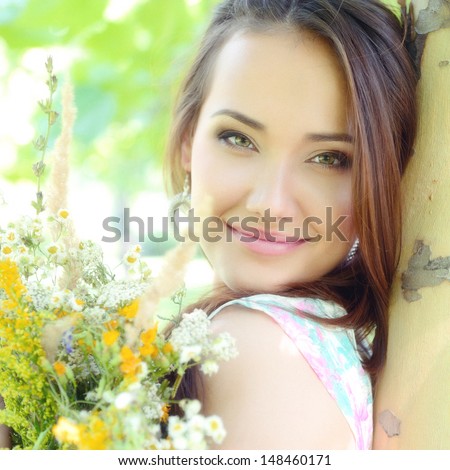 young beautiful lady with field flowers outdoor portrait, charming girl resting in summer park, toned and noise added