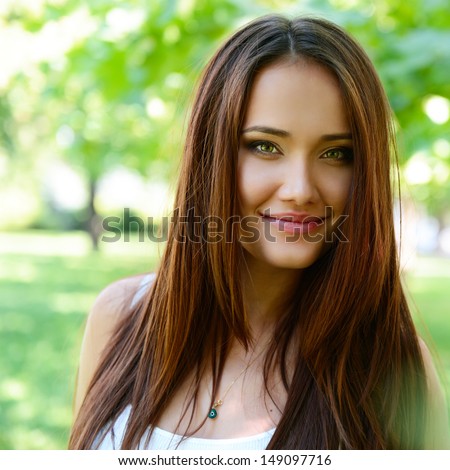 young beautiful lady outdoor portrait, girl with long brown hair posing in summer park