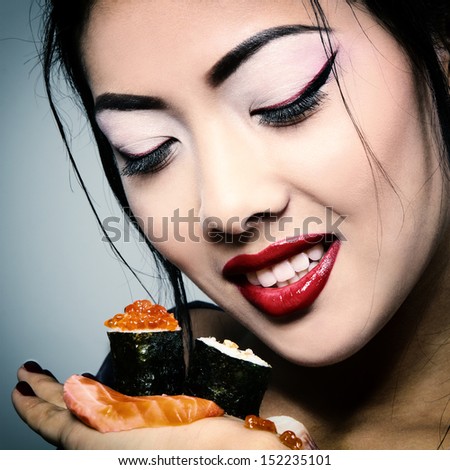 Young beautiful asian woman eating sushi, toned image and noise added