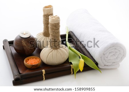 spa still life with spa herbal balls candlestick tulip stones and salt in wooden bowl and white towel over white spa still life with spa herbal balls candlestick tulip stones and salt in wooden bowl and white towel over white