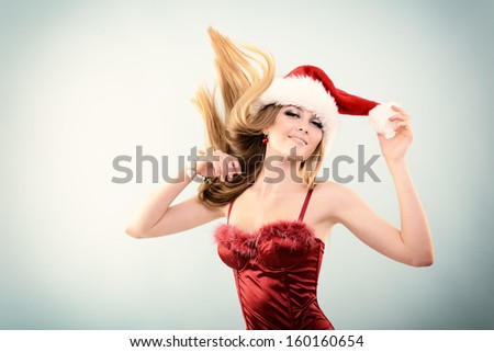 Beautiful cheerful fashion christmas girl dancing in party in Santa\'s hat, toned