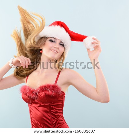 Beautiful cheerful fashion christmas girl dancing in party in Santa\'s hat