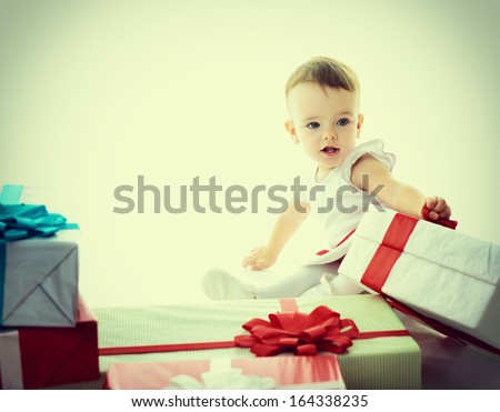 Holidays, baby girl with presents, christmas, birthday, new year, x-mas concept - happy child girl with gift boxes, toned