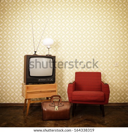 Vintage room with old fashioned armchair, retro tv, lamp and bag over obsolete wallpaper. Toned