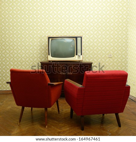 Vintage Room With Two Old Fashioned Armchairs And Retro Tv Over Obsolete Wallpaper