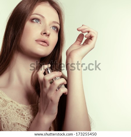 Girl With Perfume, Young Beautiful Woman Holding Bottle Of Perfume And Smelling Aroma, Toned