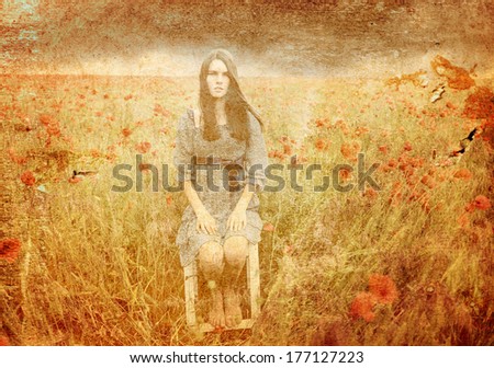 Mysterious portrait of young beautiful woman sitting on stool in a poppy field and looking at camera, summer nature outdoor. Toned, texture added.