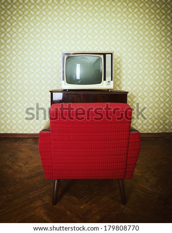 Vintage room with two old fashioned armchair and retro tv over obsolete wallpaper. Toned