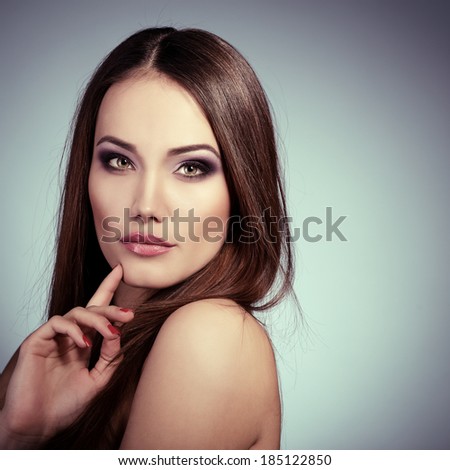 Beauty portrait of young woman with beautiful healthy face and long brown hair looking at camera.