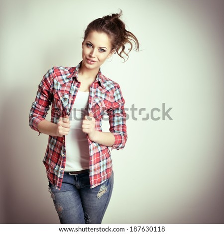 Beautiful teen girl with jeans and checkd shirt. Fashion girl. Toned.