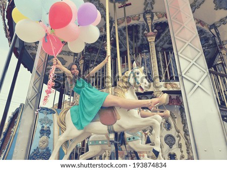 Merry-go-round young woman playing on carousel toned Merry-go-round young woman playing on carousel toned