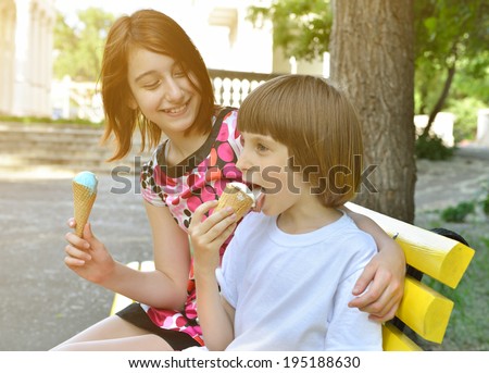 Children eating ice-cream in the summer park , toned.