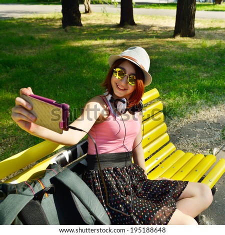 Teen girl has fun outdoor and make photos with smartphone.