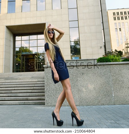 Fashion Blond Girl with Long Legs. Street Fashion. Urban Lifestyle. Young Beautiful Woman Walking Outdoor.