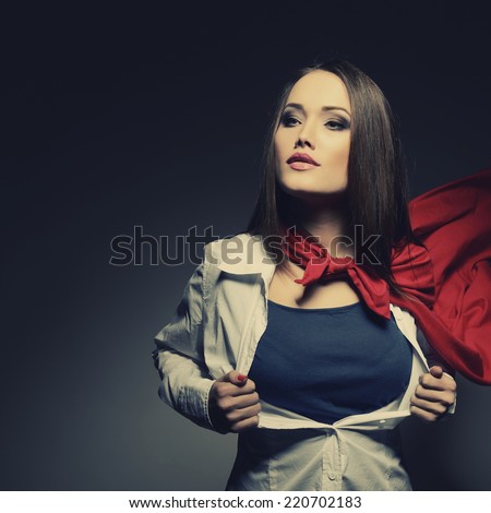 Young pretty woman opening her shirt like a superhero. Super girl, image toned. Beauty saves the world. Image toned.