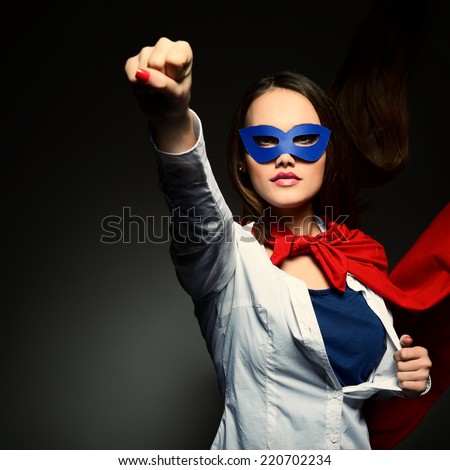Young pretty woman opening her shirt like a superhero. Super girl, image toned. Beauty saves the world.
