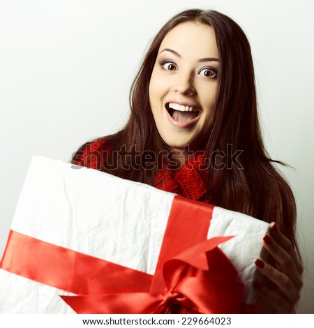 Xmas excited girl holding gift box surprised, toned