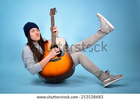 young woman playing music on acoustic guitar