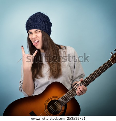 young woman playing music on acoustic guitar, toned