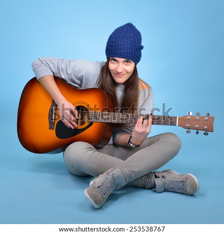young woman playing music on acoustic guitar