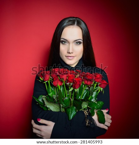 Beautiful Woman with Fresh Red Roses. Girl and Flowers over Red Background. Beauty Female Face. Happiness, Freshness, Beauty, Youth.