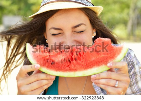 Happy young woman eating watermelon on the beach. Youth lifestyle. Happiness, joy, holiday, beach, summer concept.