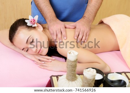 Body care. Beautiful young woman relaxing with hand massage at beauty spa salon. Back manual massage.