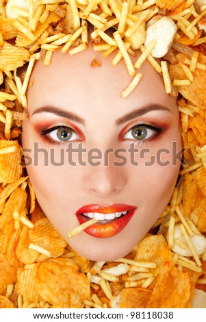 portrait of beautiful cheerful young female face with unhealthy eating fast food potato chips and rusk frame