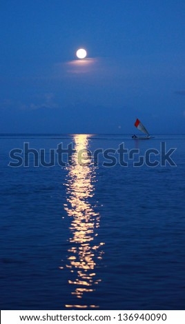 Moon with reflection in the water, and the boat. Bali, Indonesia