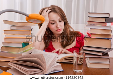 Tired student having a lot to read. Student girl with lot of books around. Student is studding. Study up.