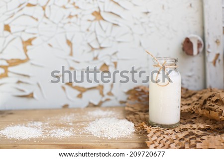 Natural milk bottle standing on a wooden table on a background of old furniture. Still-life with natural healthful food. Dairy