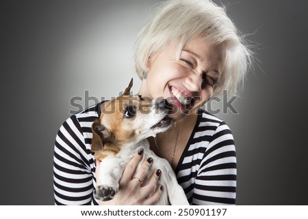 Cheerful beautiful woman laughs plays fooling around with a dog