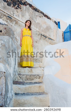 Walking alone in the mysterious streets of the old city. Bright beautiful girl walking down the stairs in a long feminine dresses
