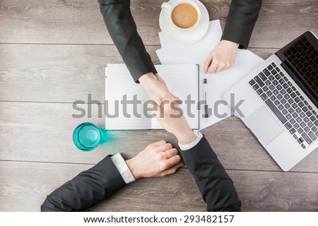 Businessman and businesswoman meeting Handshake. Hand holding. Top view for top managers.  White paper, where you can place your text or information