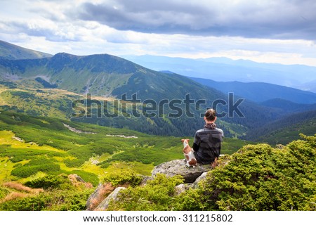 one man and loyal friend dog watching the beautiful pensive dreamy magical mountain landscape. Time for reflection. Harmony with yourself.. Series of photos