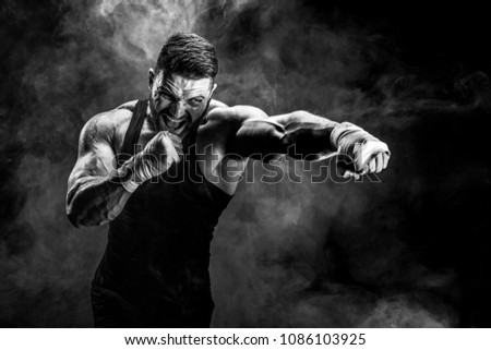 Sport concept. Sportsman muay thai boxer fighting on black background with smoke.