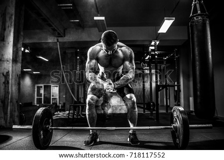Muscular fitness man preparing to deadlift a barbell over his head in modern fitness center.Functional training.Snatch exercise