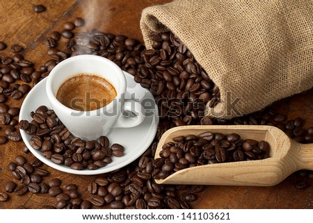 coffee cup with jute bag and spoon full of coffee beans