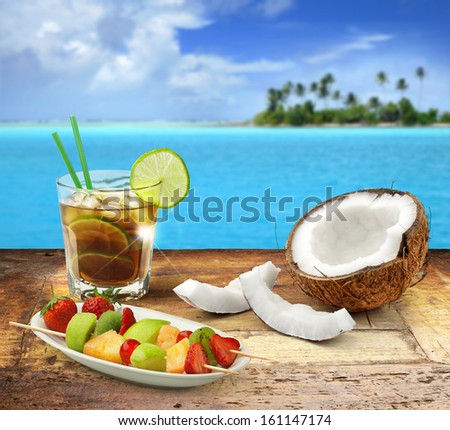 Cuba Libre And Tropical Fruit On A Wooden Table In A Polynesian Seascape