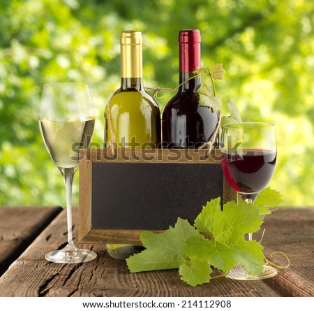 wine bottles and small blackboard on wooden table