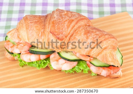 sandwich with shrimp salad isolated on a wooden cutting board