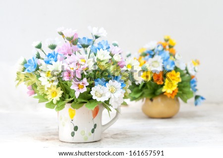 Many flower in the vase on the white table.