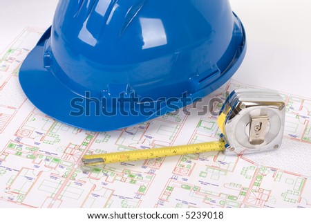 Safety headgear and measuring tape on a house plan