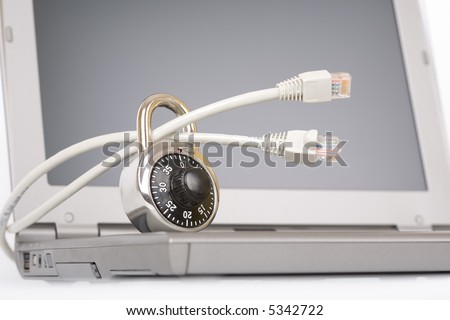Closed padlock on network cables on a laptop - over a white background