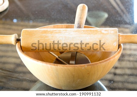 wooden roller and cutter pizza on wood bowl