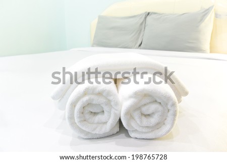 bath towels rolled on bed