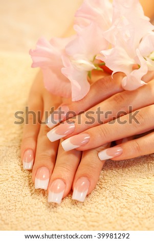 Hands of young woman with french manicure on the towel