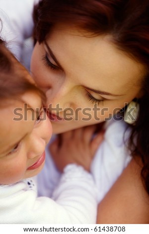 stock photo Young attractive mother is kissing her naughty little girl